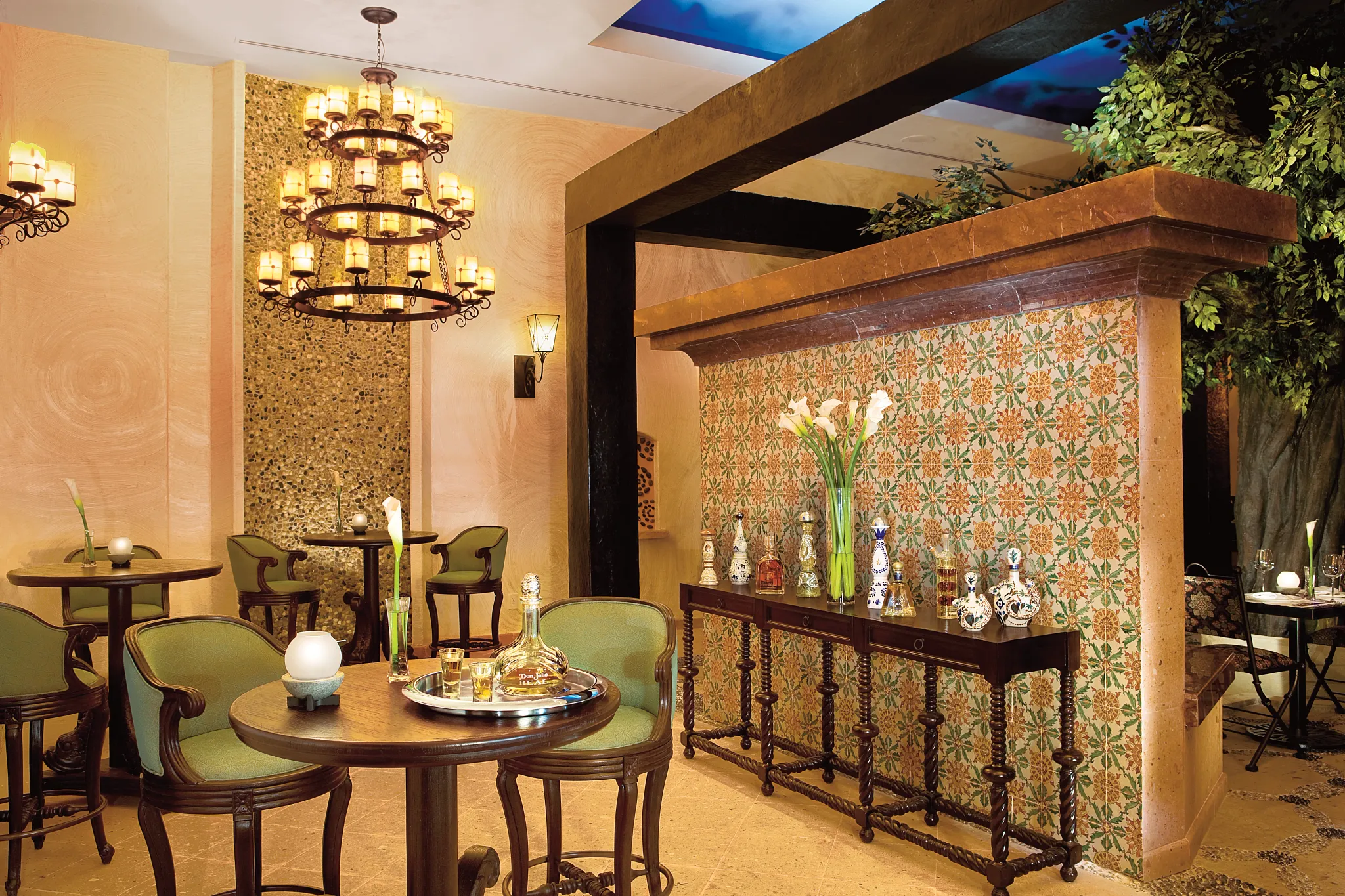 Traditional Mexican décor and tequila display at El Patio restaurant at Secrets Maroma Beach Riviera Cancun.