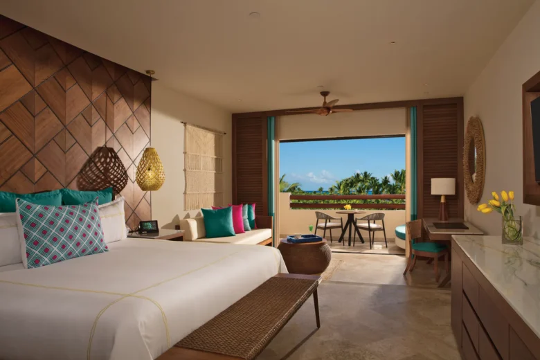 Junior Suite Partial Ocean View with king bed and balcony overlooking the Caribbean at Secrets Maroma Beach.