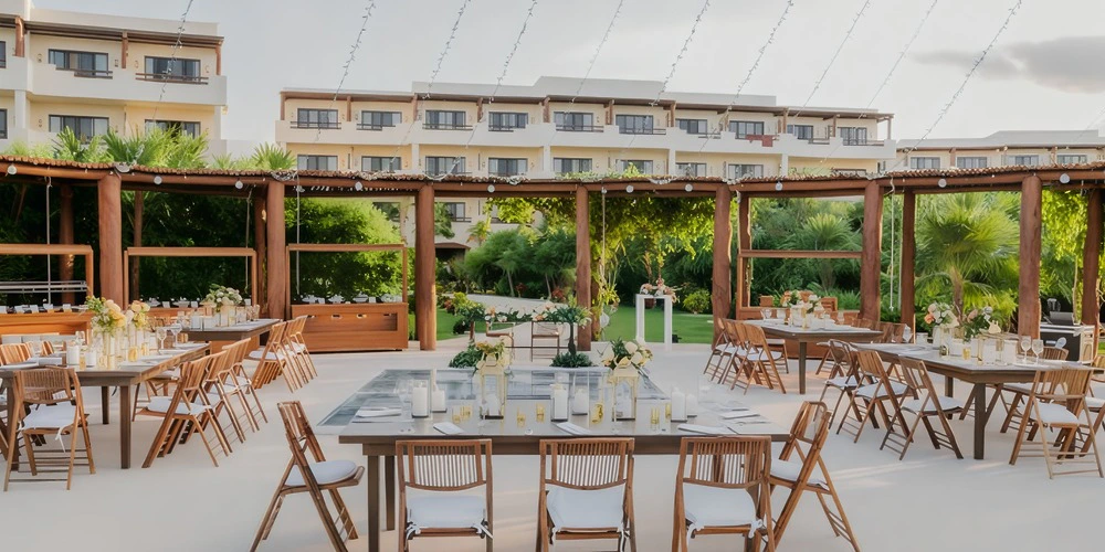 Oceana Terrace Venue at Secrets Maroma Beach set for an elegant outdoor reception with wooden tables, floral centerpieces, and lush tropical garden views.