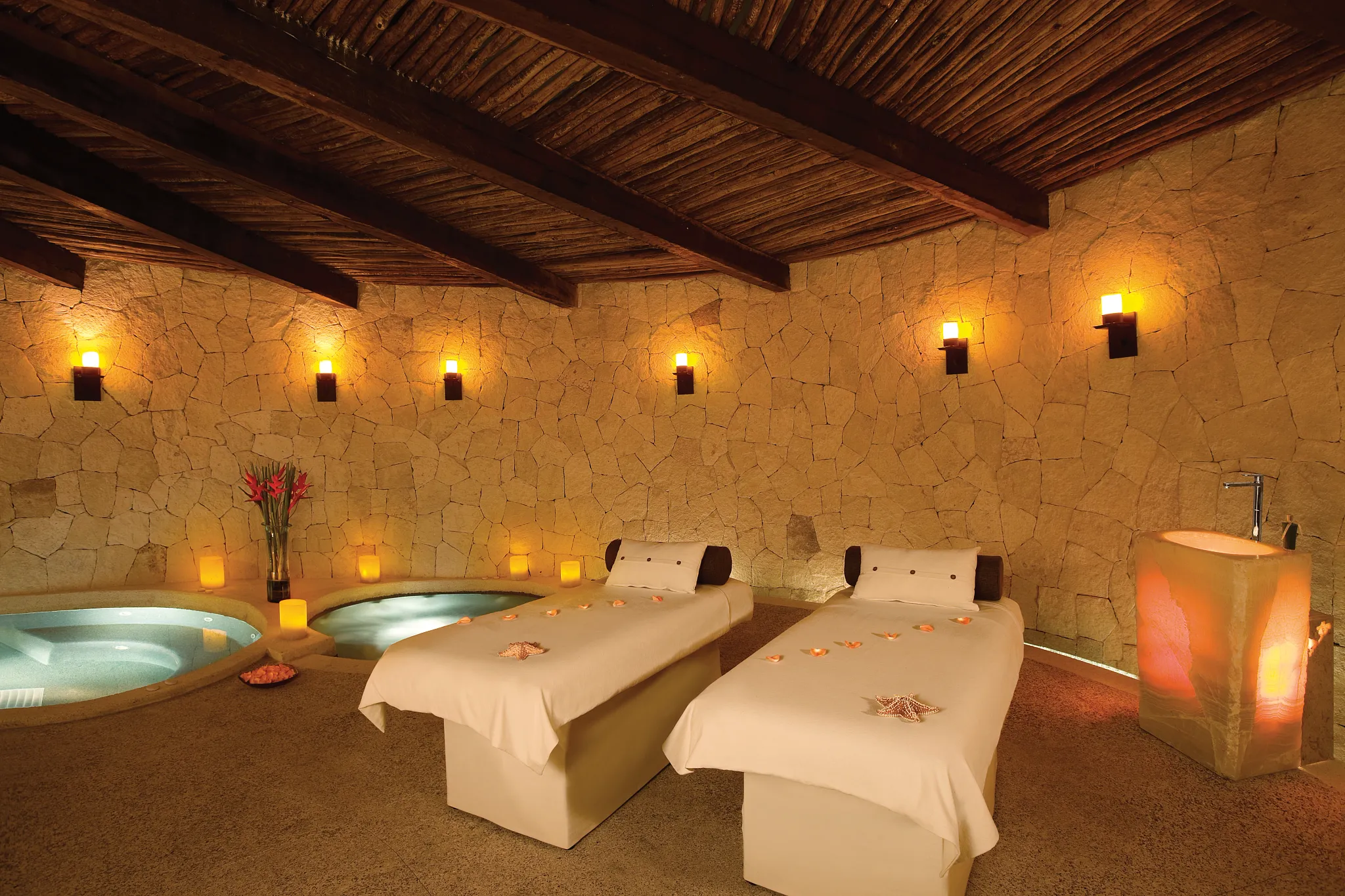 Outdoor spa treatment cabana with massage tables and hydrotherapy pools at Secrets Maroma Beach Riviera Cancun.