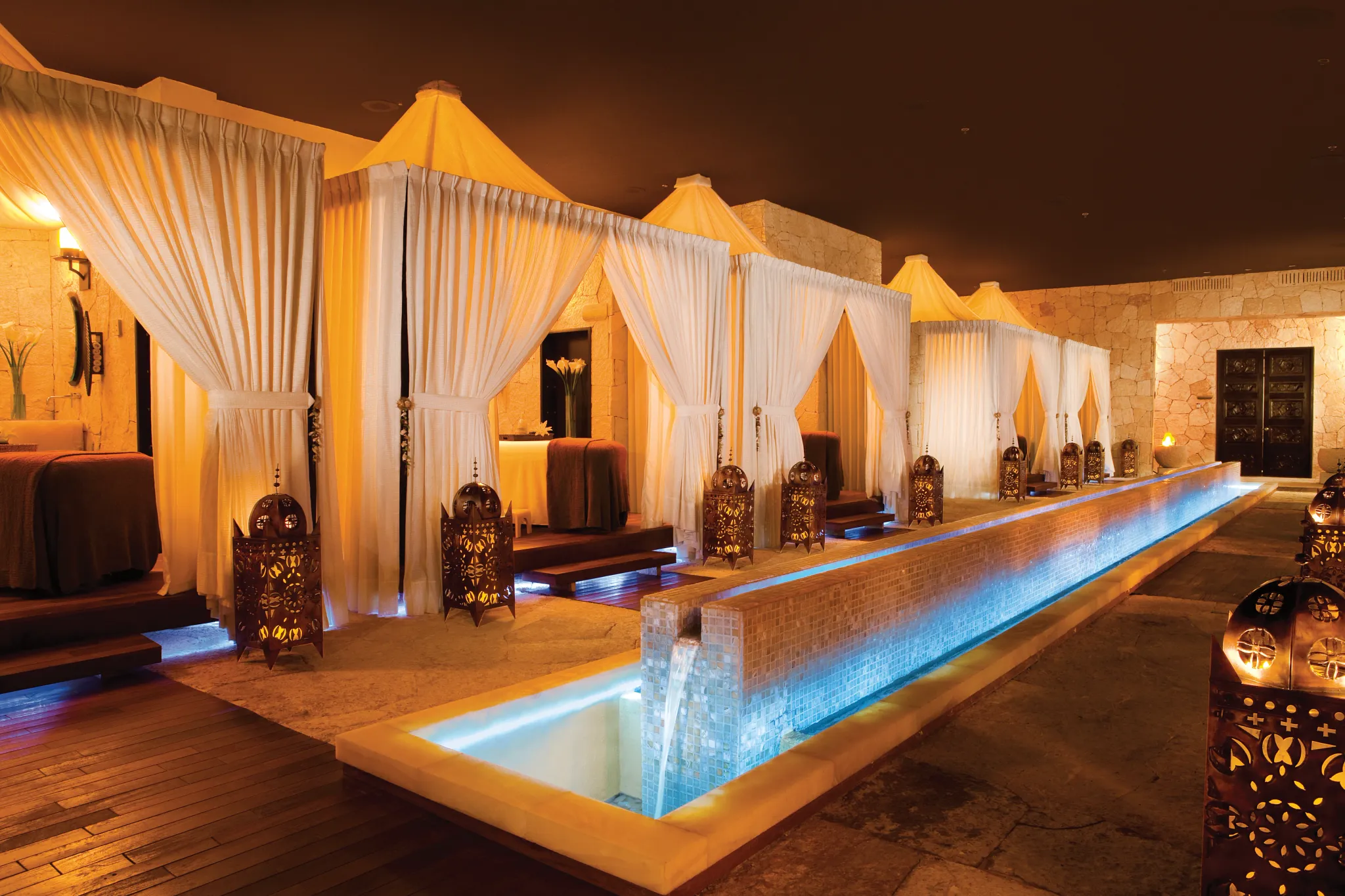 Candlelit spa cabanas with flowing white curtains at Secrets Maroma Beach Riviera Cancun.